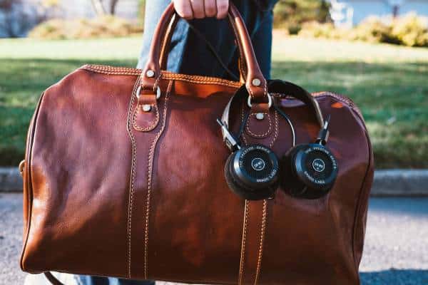 A sophisticated leather duffel bag with high-quality headphones, a stylish travel companion.
