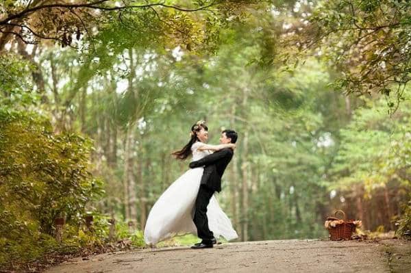 Bride and grooms romantic dance in enchanting forest setting.
