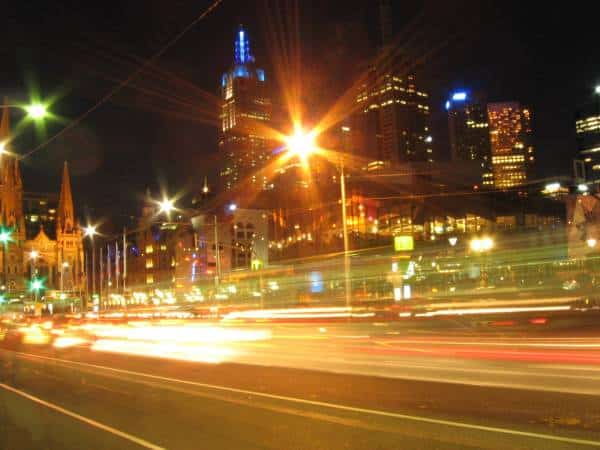Vibrant city skyline at night, with illuminated skyscrapers and flowing traffic.