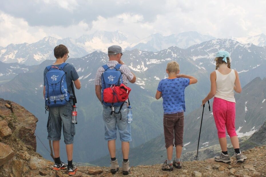 Outdoor adventurers marvel at stunning mountain panorama on hiking expedition.